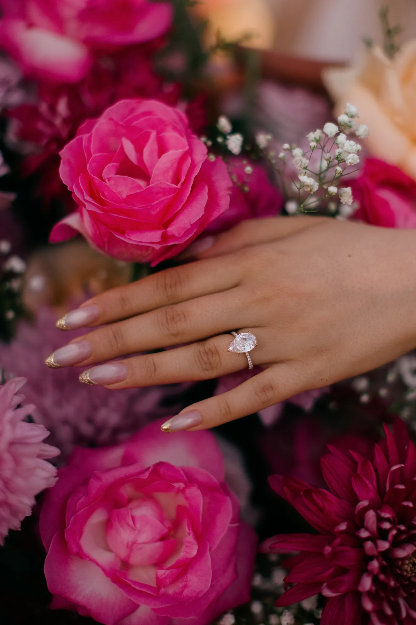Engagement ring on pink roses at a Bali beach proposal