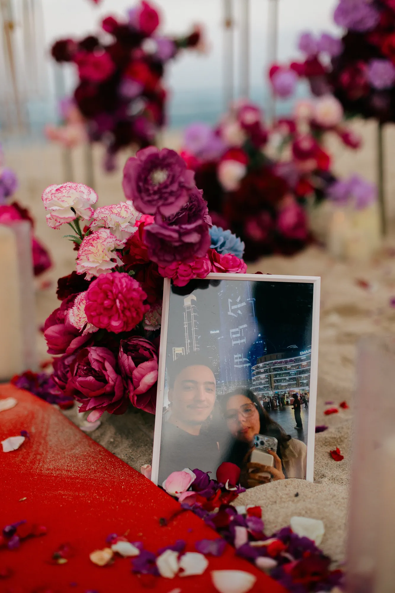 Framed couple photo among red roses at a beach proposal in Bali