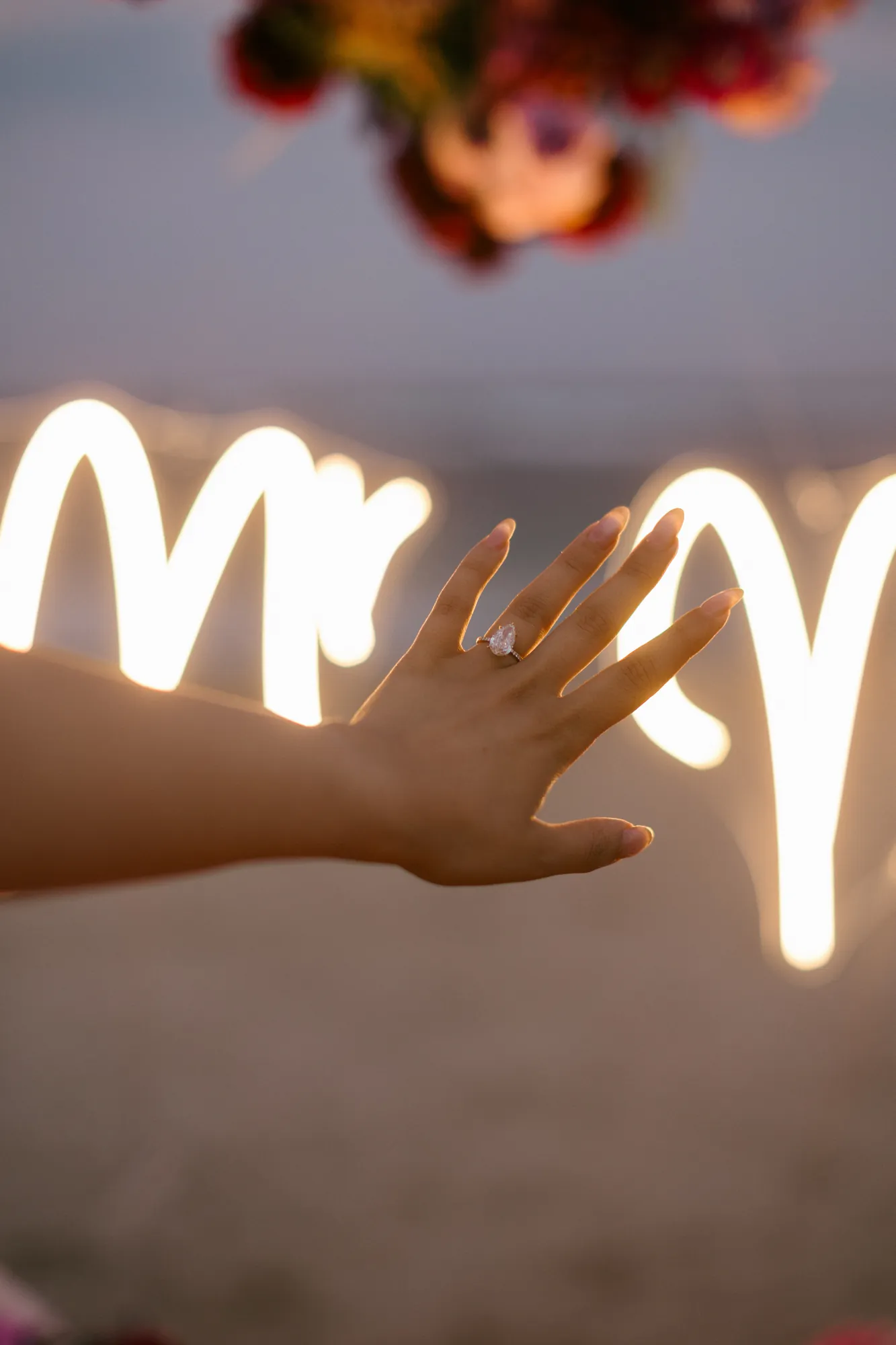 Will you marry me written in light at a Bali beach proposal
