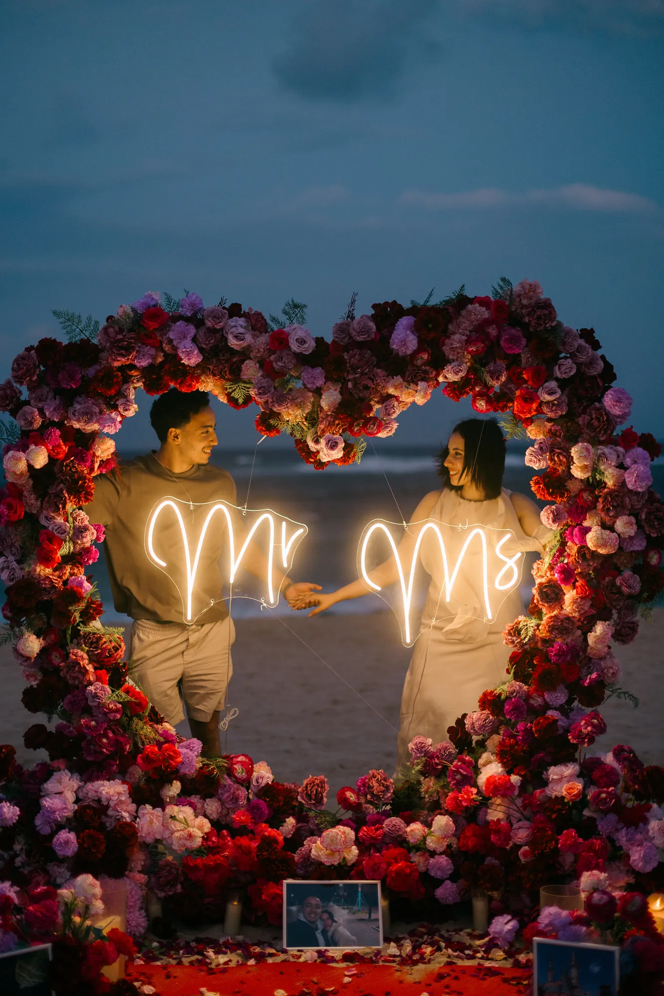 Couple with a Mr and Mrs neon sign at a Bali beach proposal