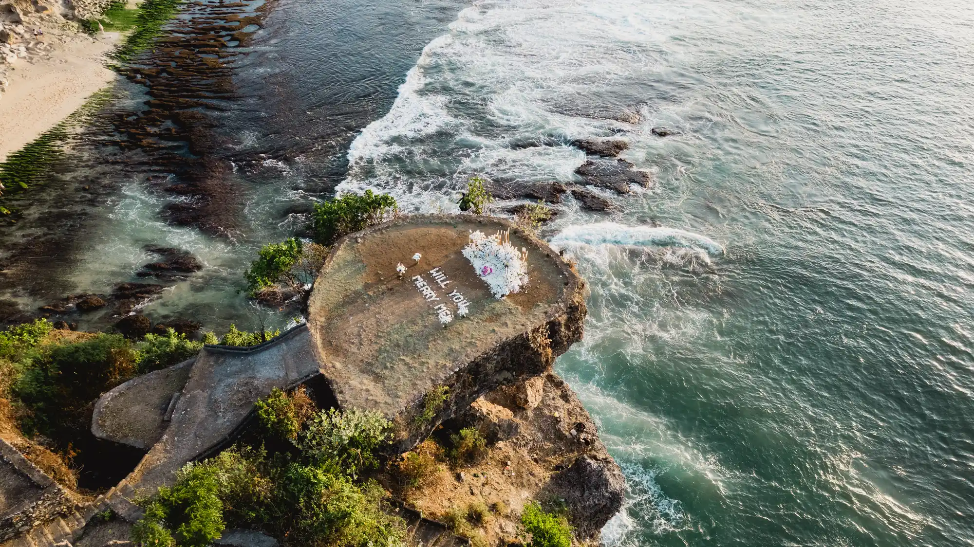 Aerial view of a Balangan cliff proposal rock surrounded by ocean in Bali
