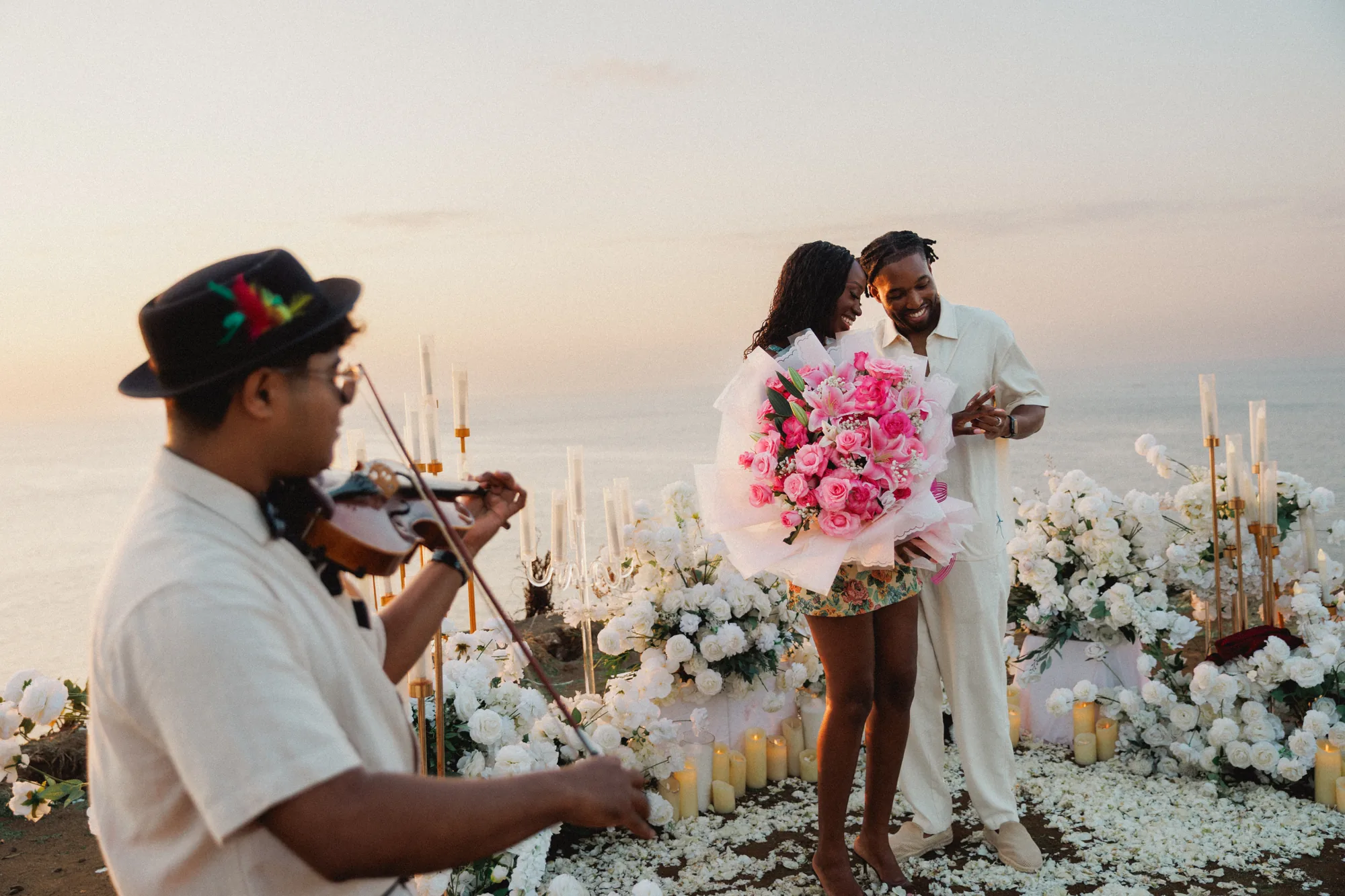 Live violinist playing at a couple's clifftop proposal in Balangan, Bali