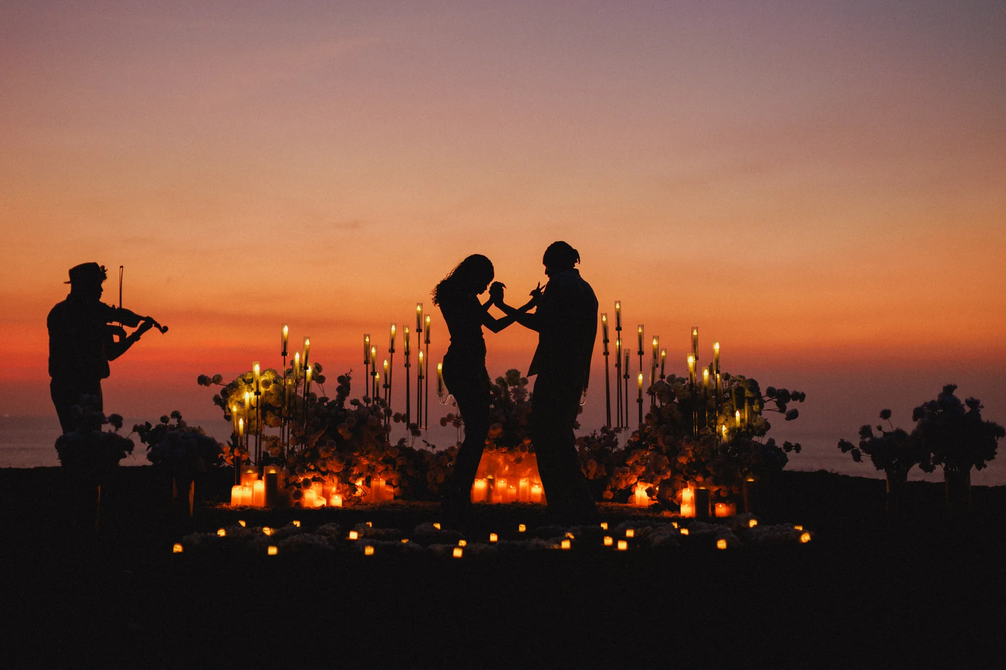 Man lifting his partner in silhouette at sunset in Bali