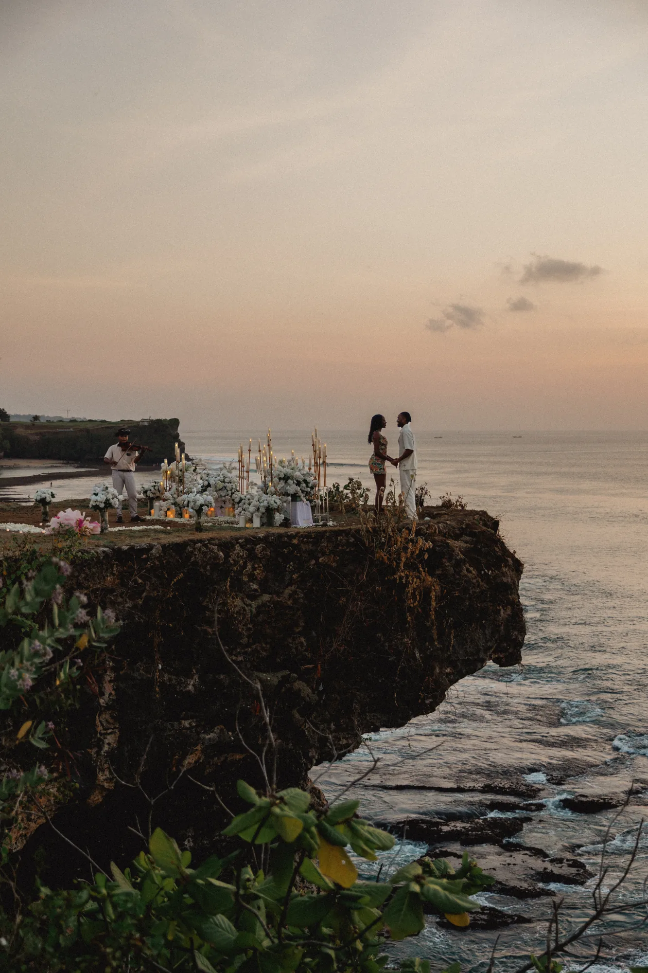 Couple on a Balangan cliff edge above the ocean in Bali