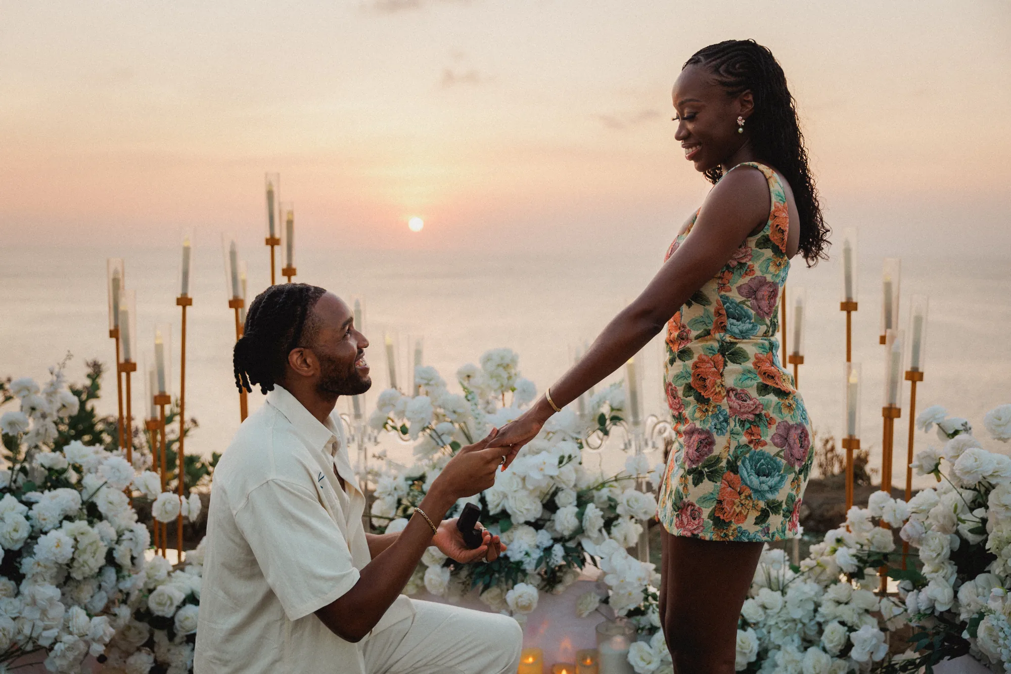 Man kneeling to propose at sunset on a Bali clifftop