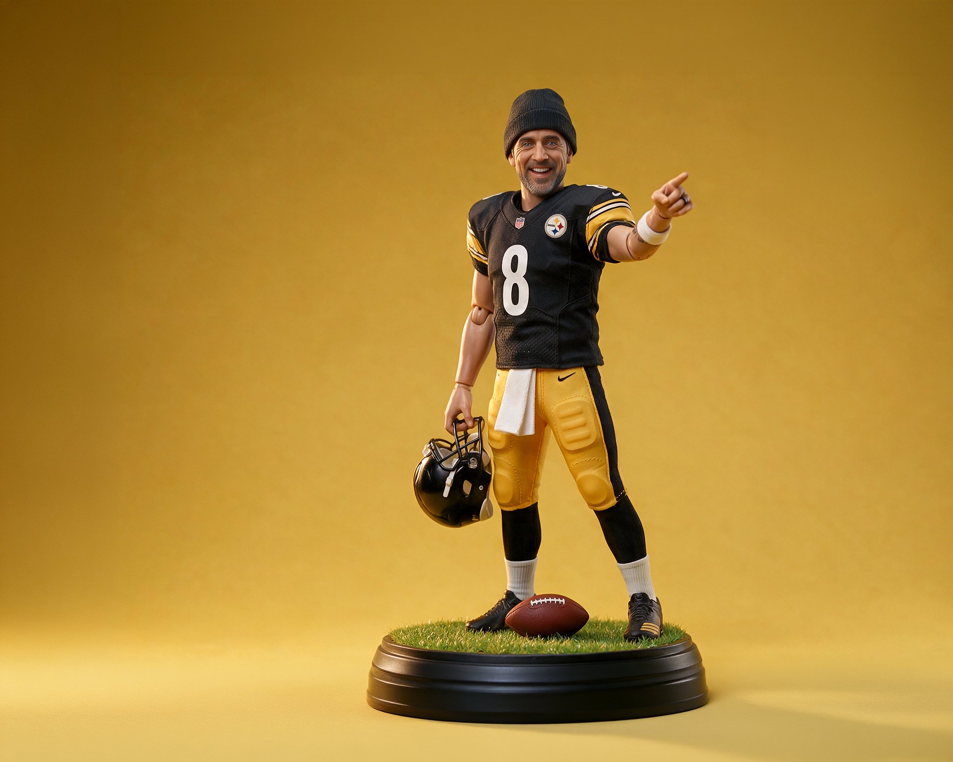NFL Toyetics key art: an Aaron Rodgers collectible figure in a Steelers uniform and black beanie, pointing, on a turf display base against seamless gold