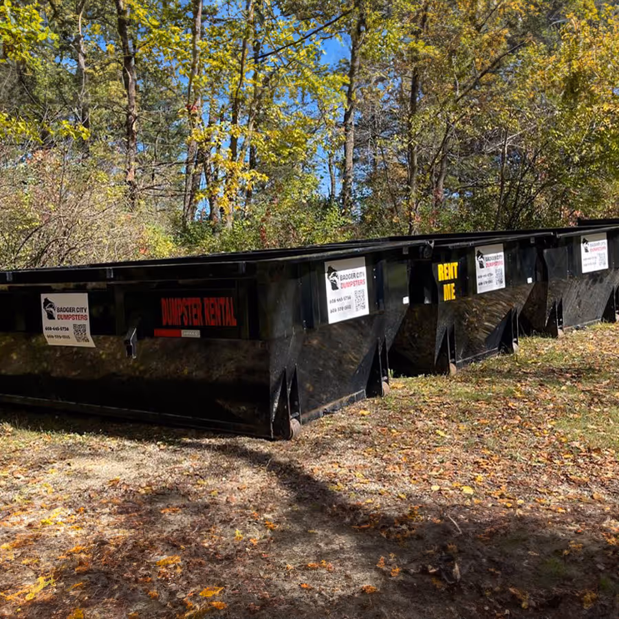 Several dumpsters in a field