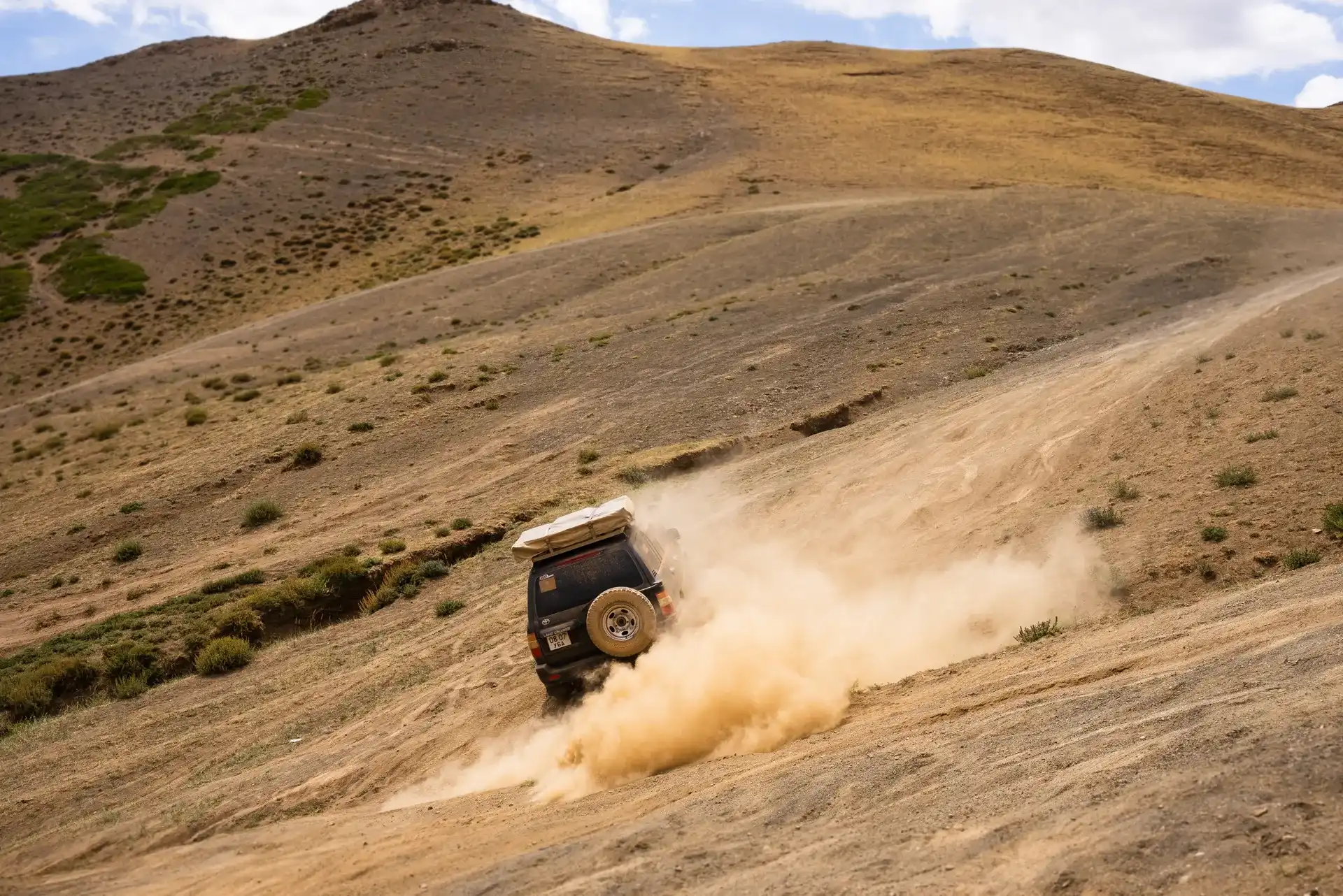 A car through remote desert landscapes during a Nomadic Road expedition
