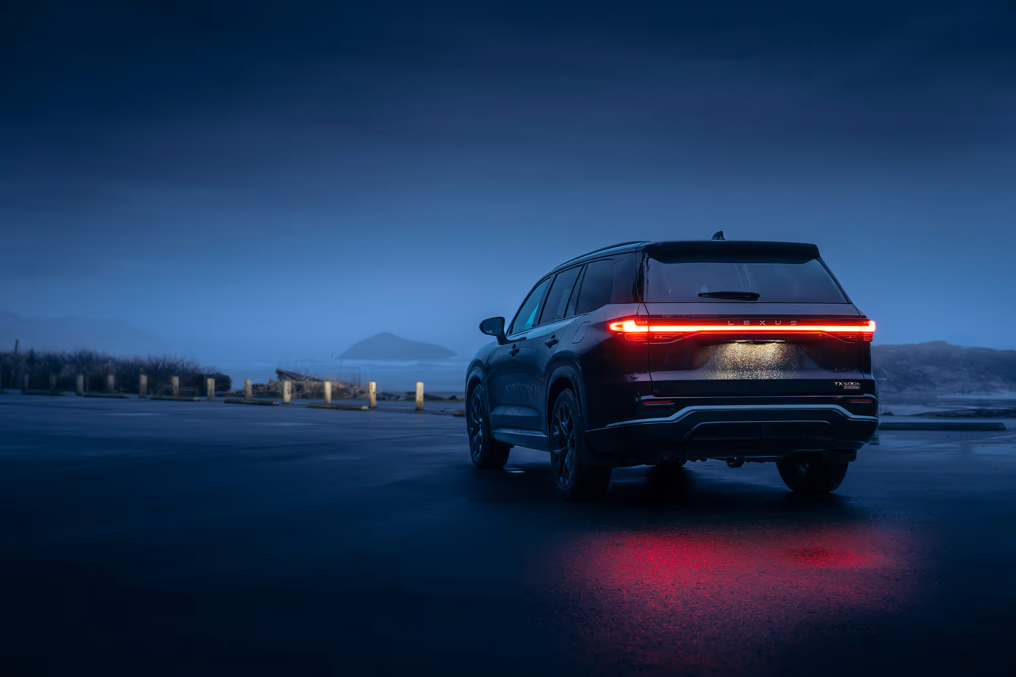 A Picture of a Lexus SUV in the early evening overlooking an ocean landscape with an island in the distance. Used as an advertising photo for Lexus
