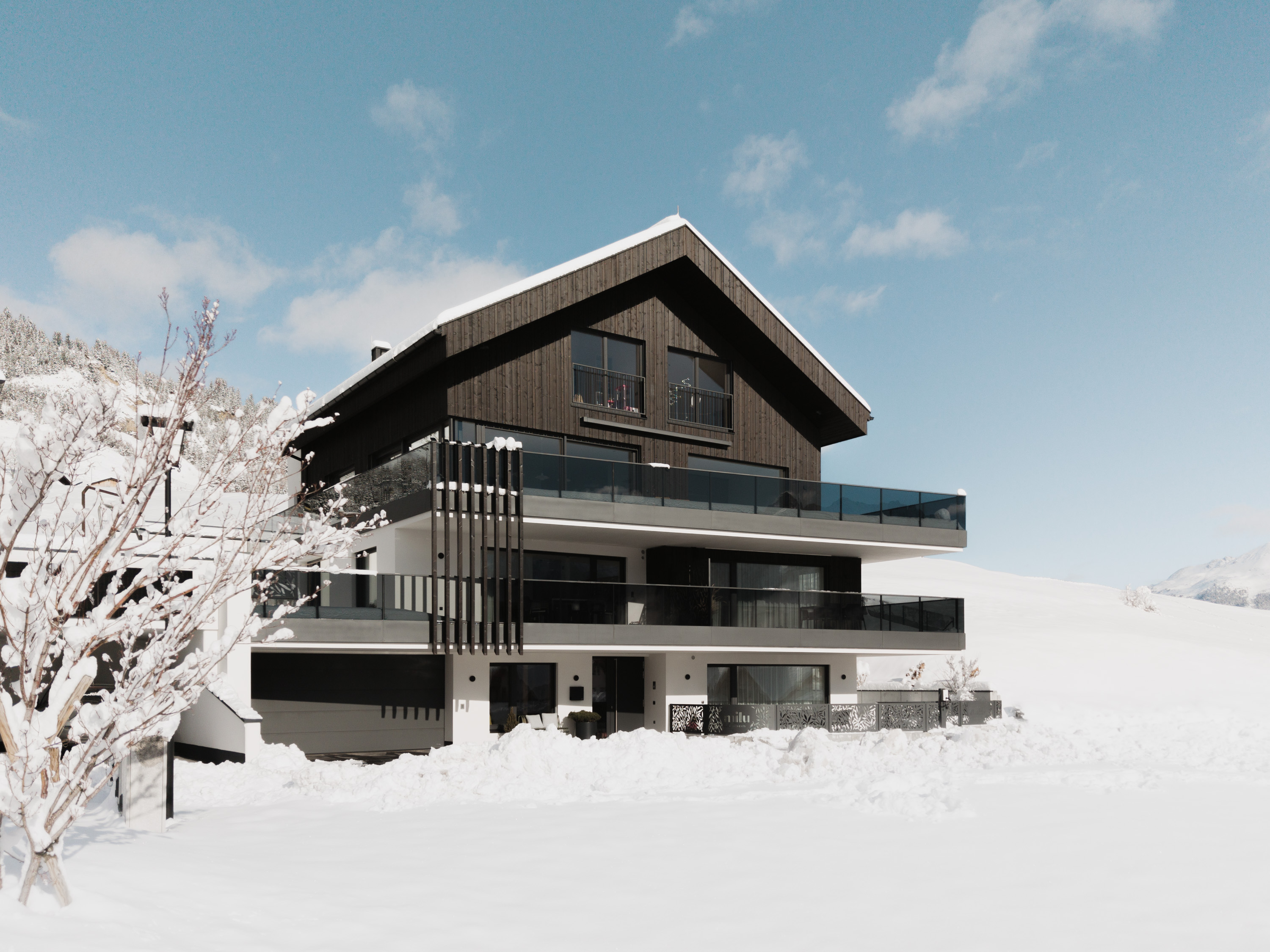 Milu Apartments Rendering vom Haus im Winter Fiss