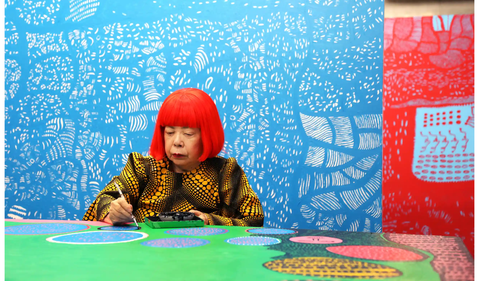 Yayoi Kusama travaillant dans son atelier, devant sa peinture Le Moment en Mouvement Quand Je Suis Allée dans l’Univers. ©YAYOI KUSAMA