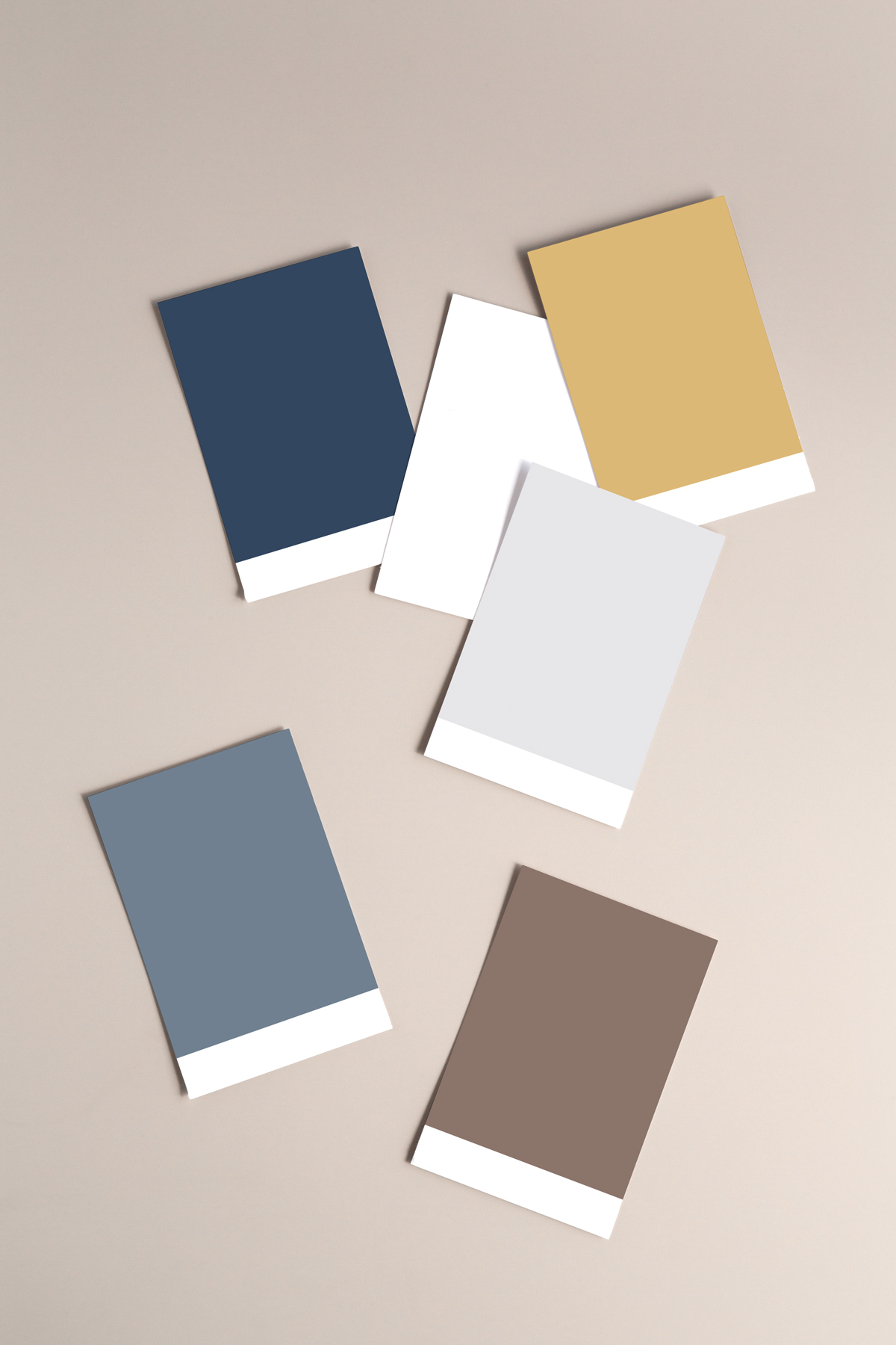 Six rectangular color swatches in navy blue, white, gold, light gray, slate blue, and taupe arranged on a neutral background.