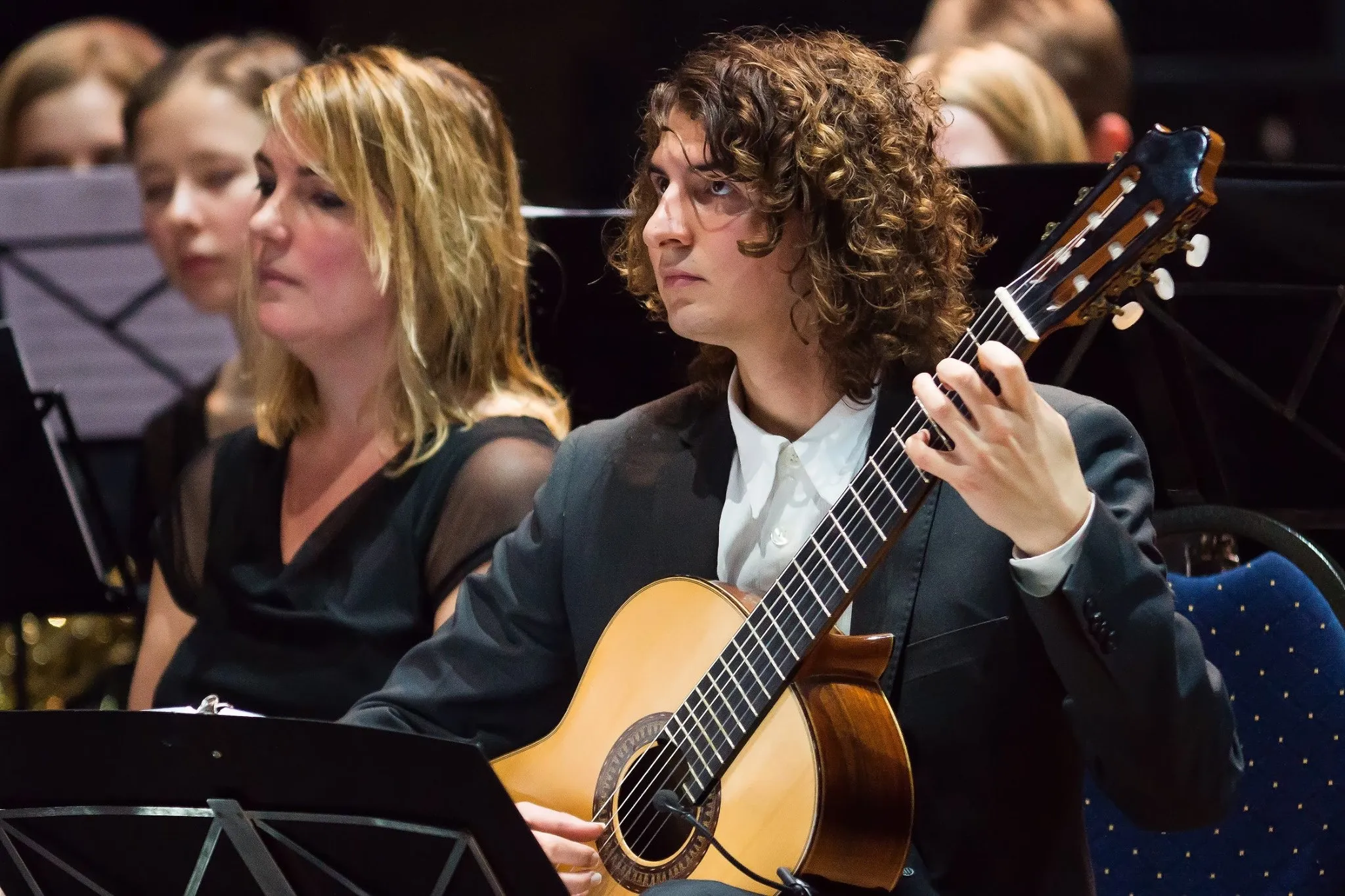 Silvan de Smit playing classical guitar with an orchestra.