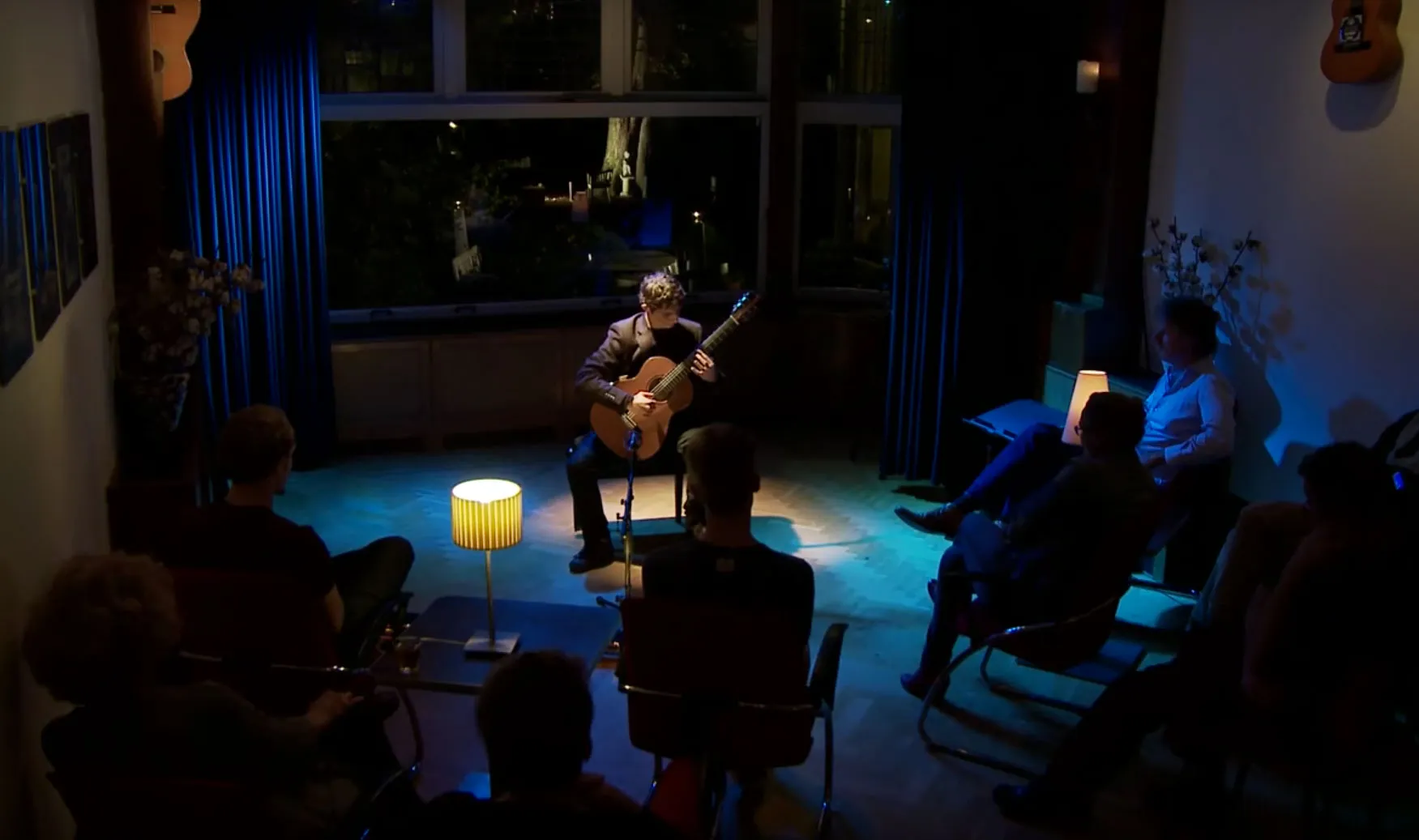 Silvan de Smit performing classical guitar at an intimate guitar salon concert.