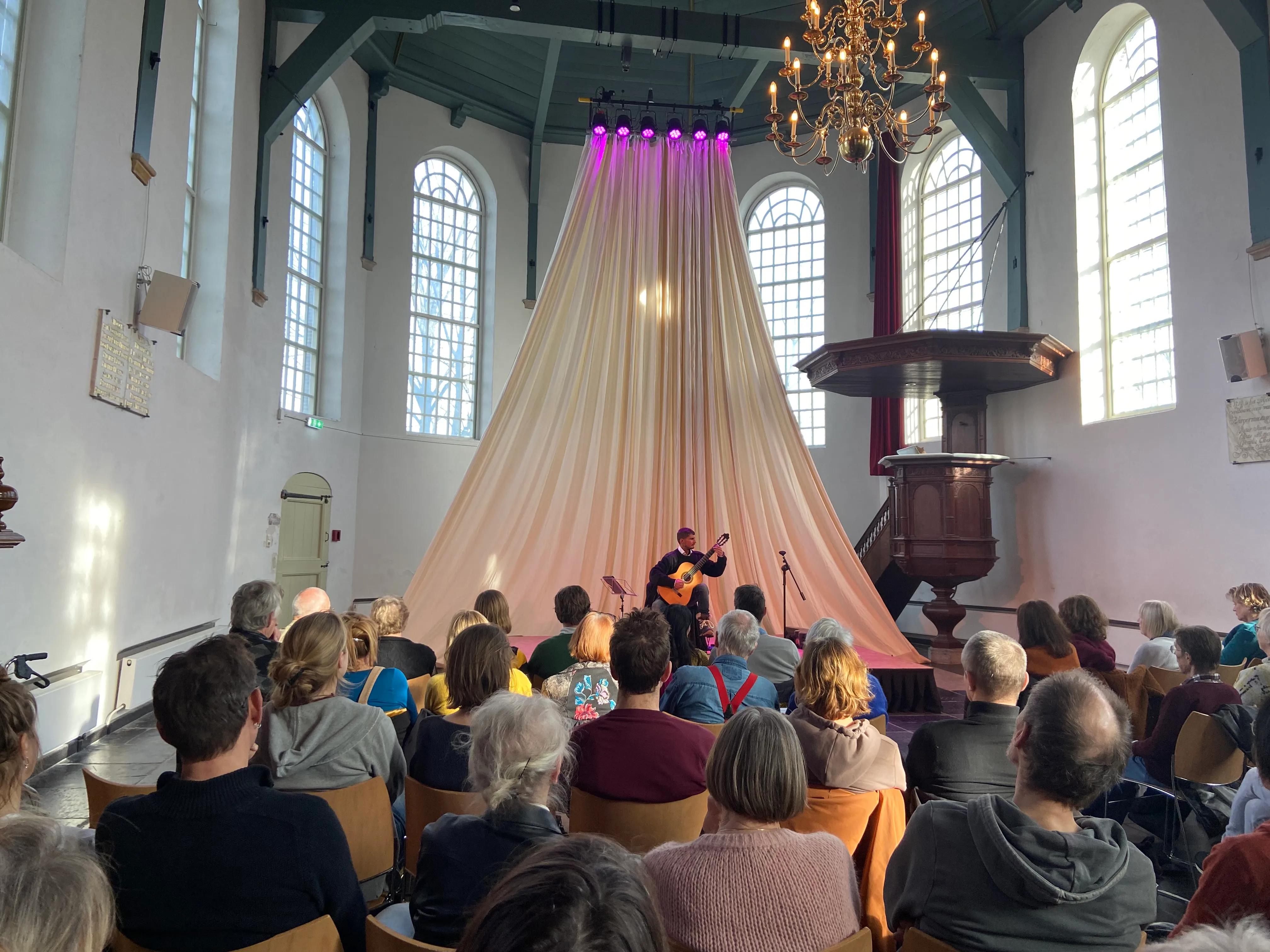 Silvan de Smit speelt klassieke gitaar voor publiek in een kerk.