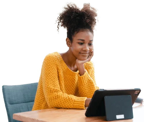 A girl in a yellow sweater is happily working on a tablet