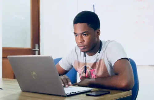 A student is working on his laptop at home