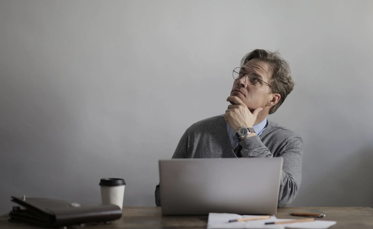 a man sitting behind a desk looking up