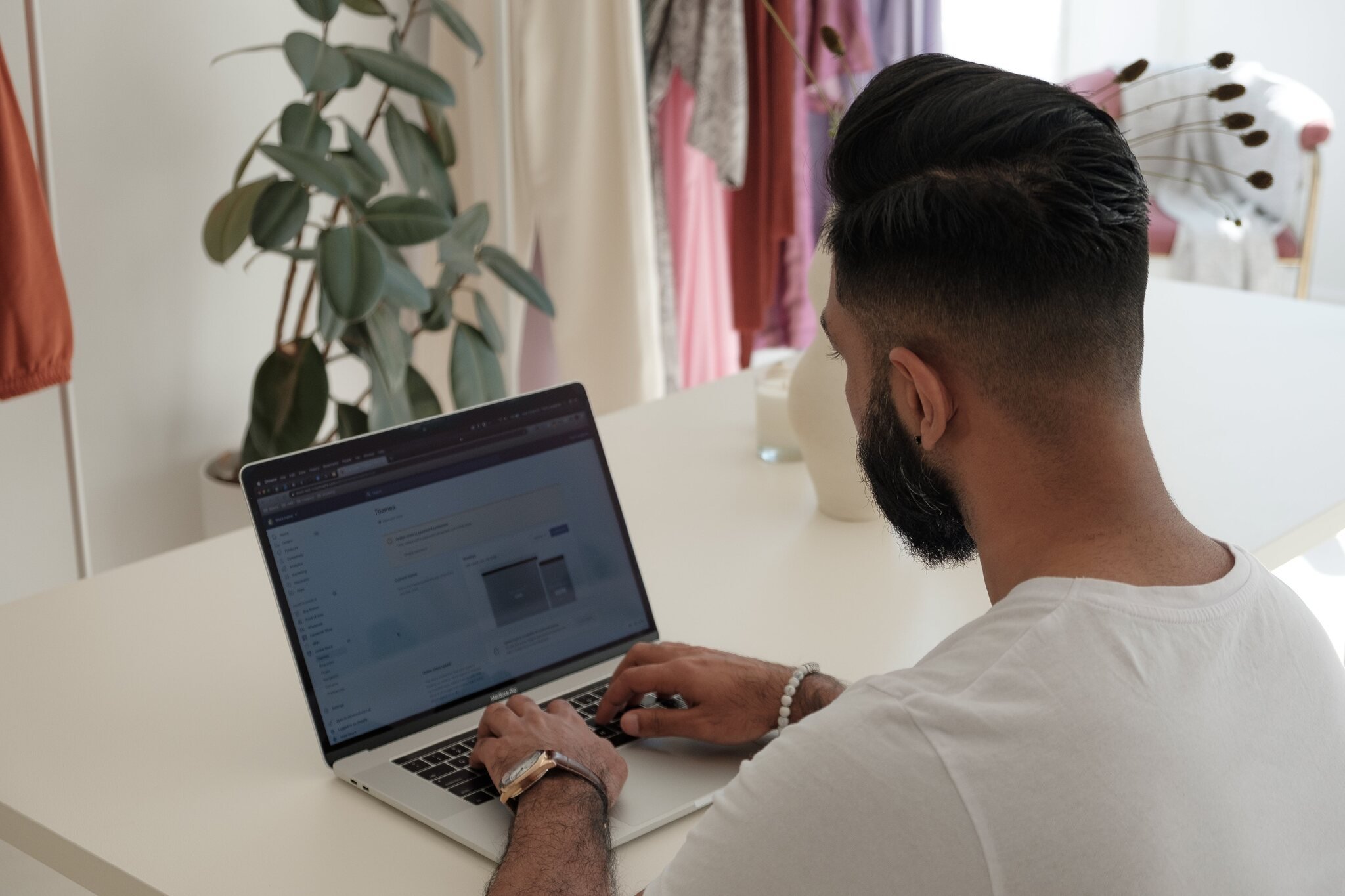 over shoulder man typing on laptop