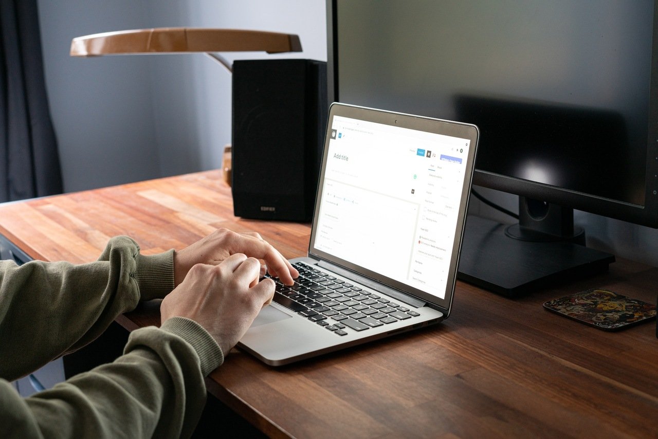 person in gray jacket using MacBook Pro checking WordPress