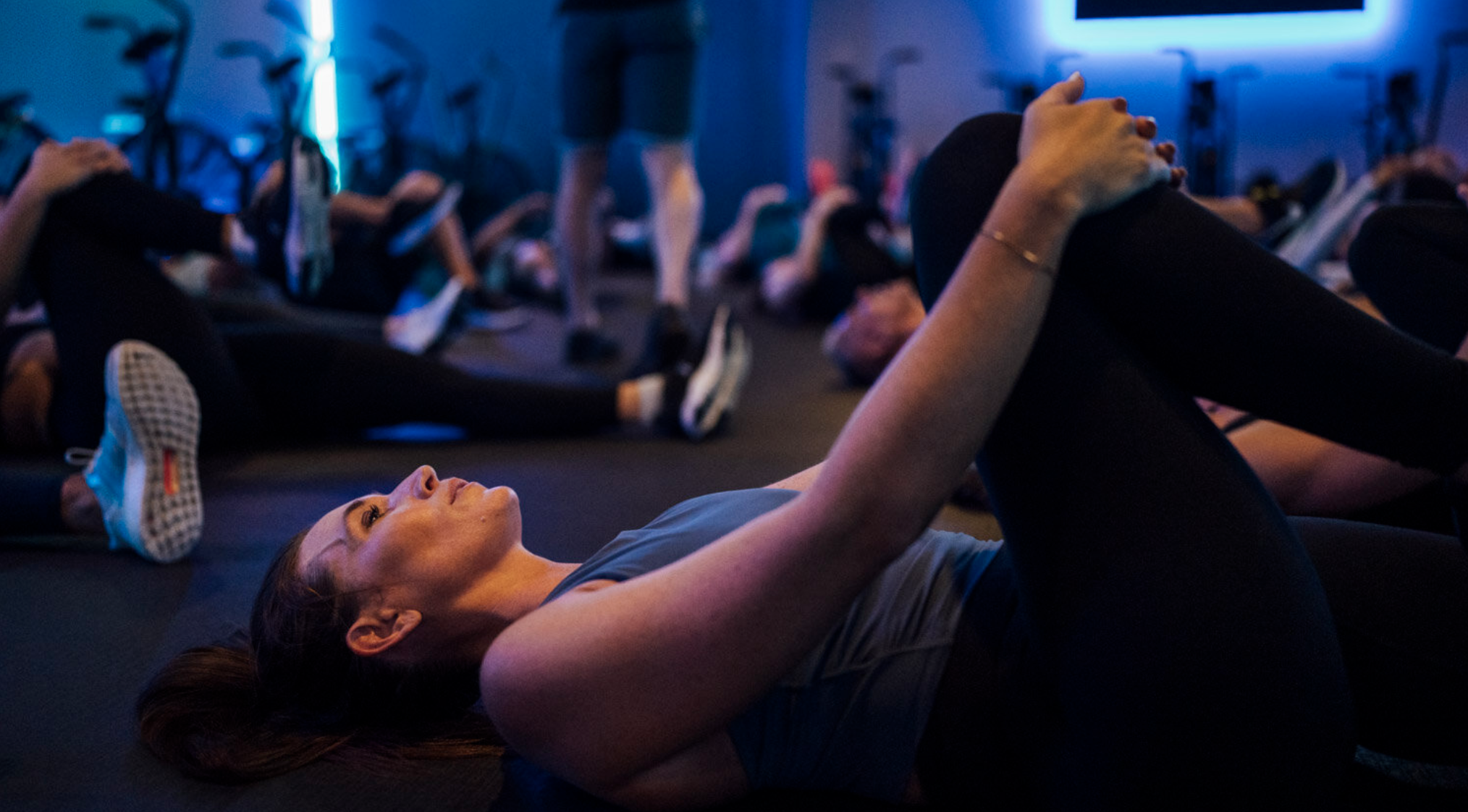 Person stretching after a workout to reduce muscle soreness, improve flexibility, and support recovery.