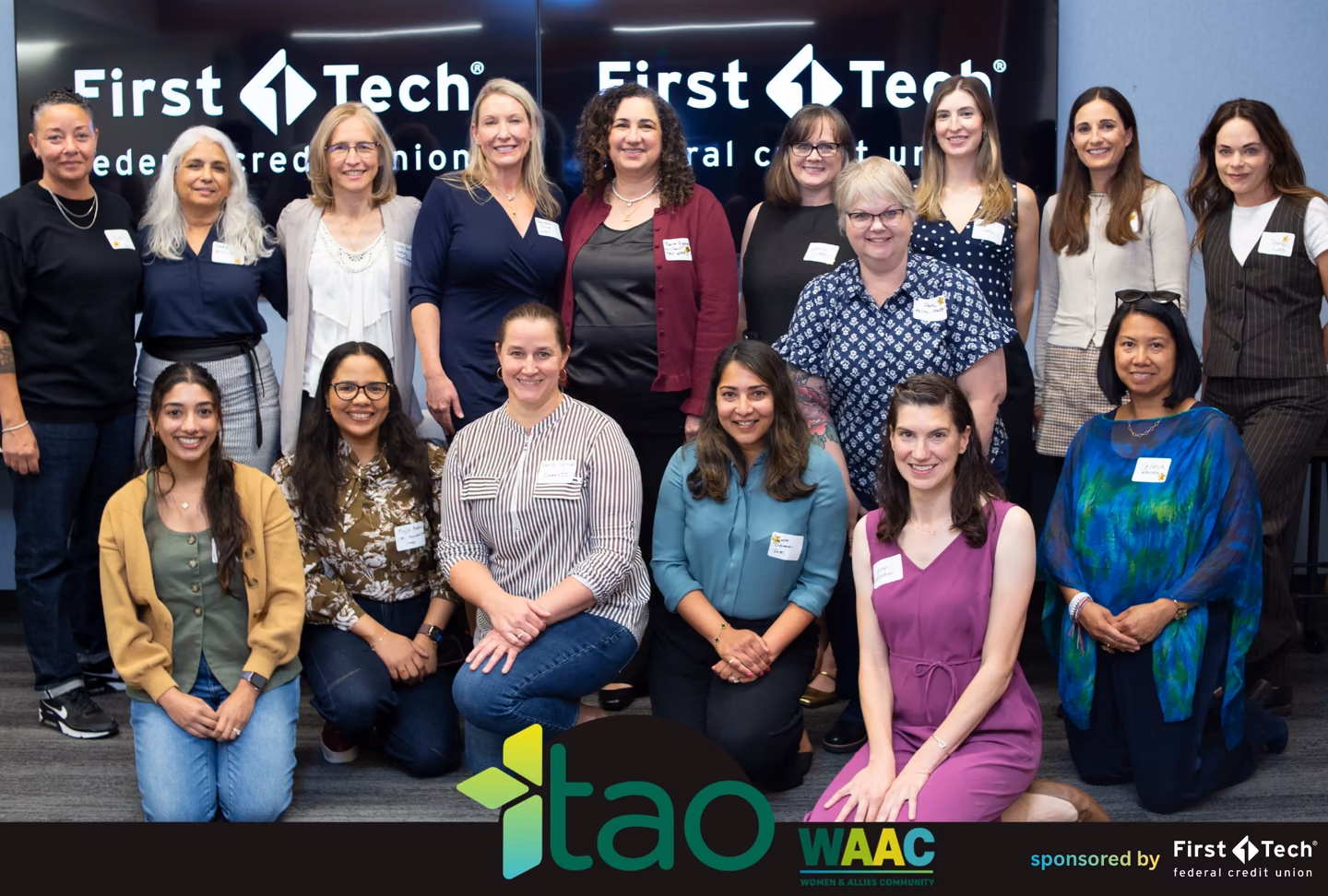 Group photo of Beyond the Build attendees, panelists and organizers in front of First Tech screens