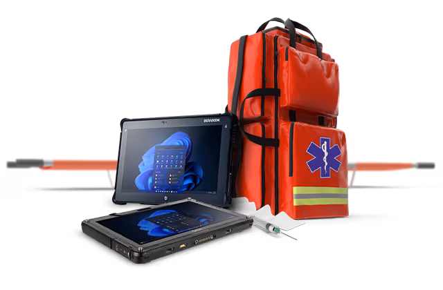 Tablet medyczny obok czerwonego plecaka ratunkowego z symbolem medycznym.