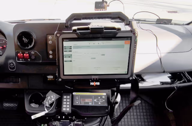 Dashboard of a vehicle with a mounted Havis tablet showing a software interface, control panel, and communication devices.