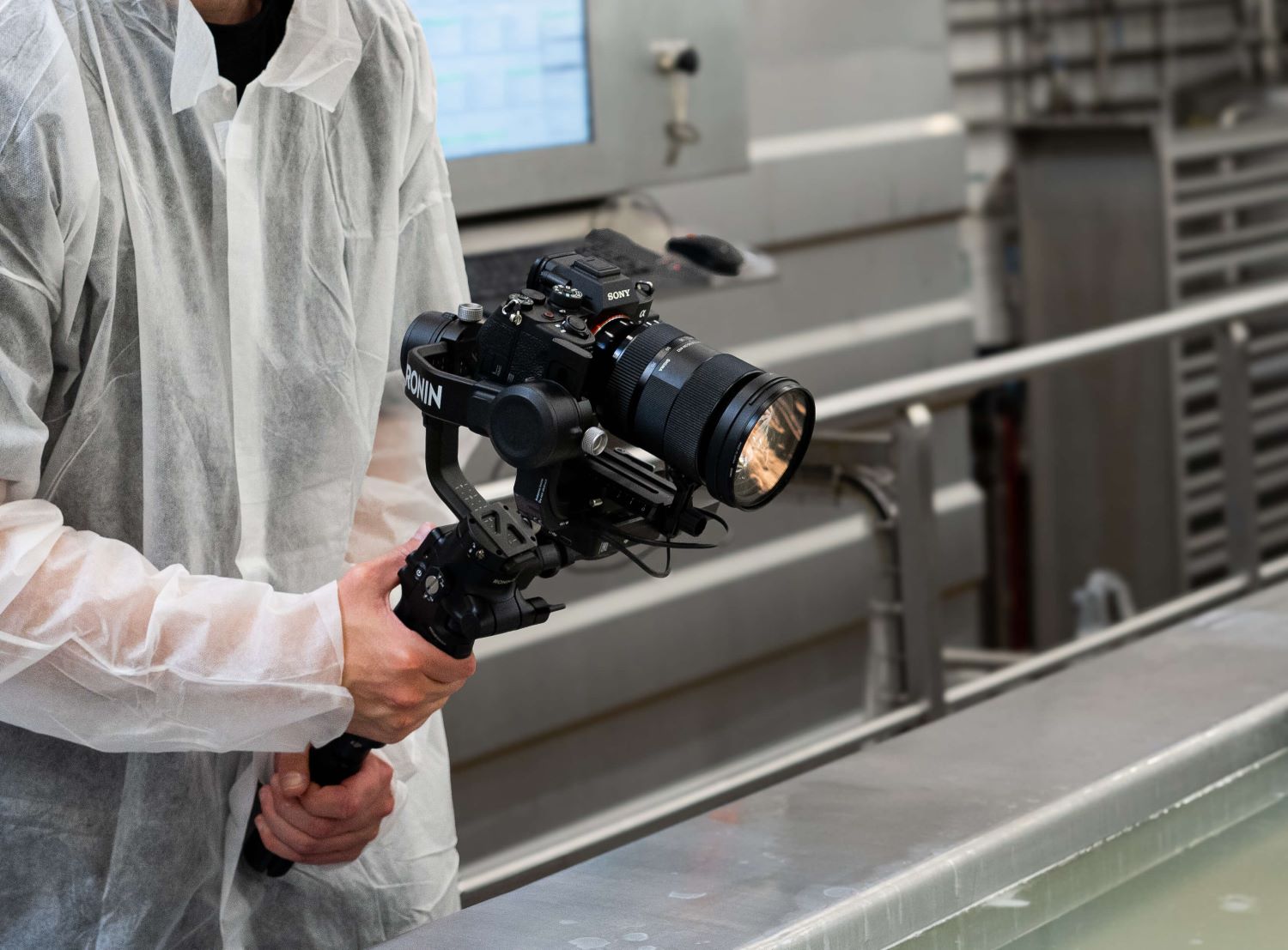 Mand i beskyttelsesdragt filmer med et kamera