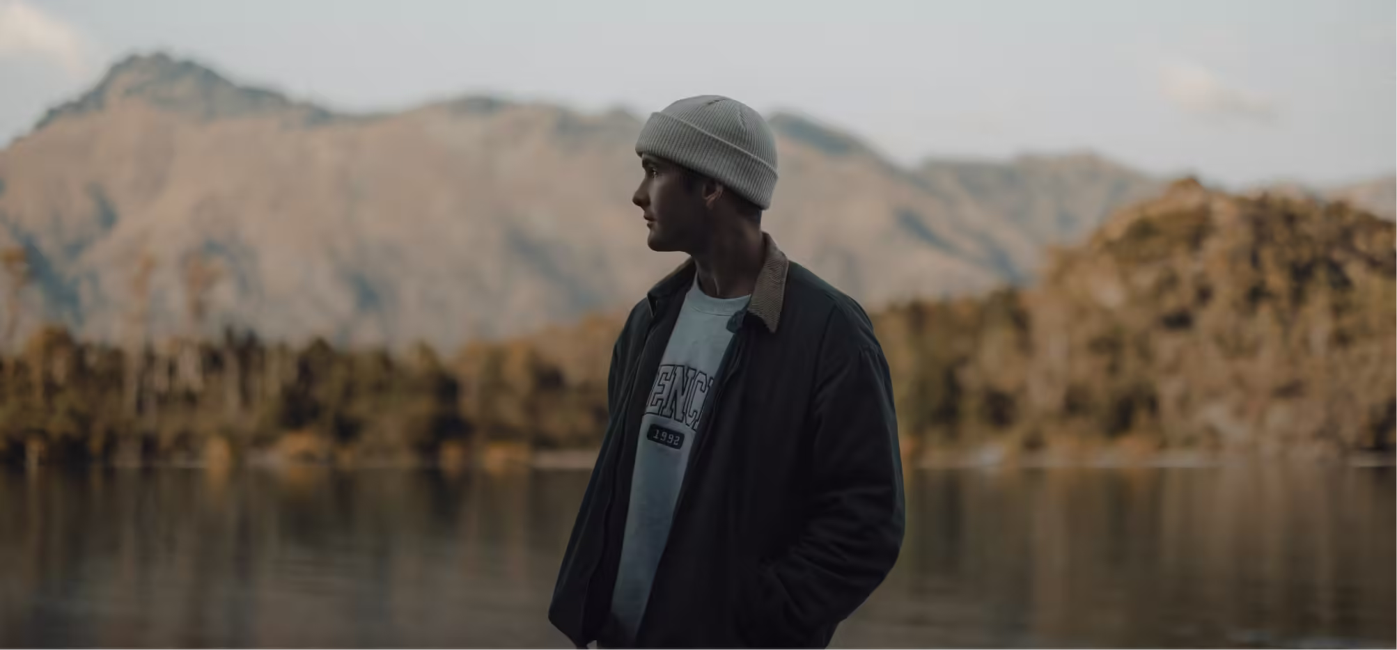 a man in a white hat looking out to the water