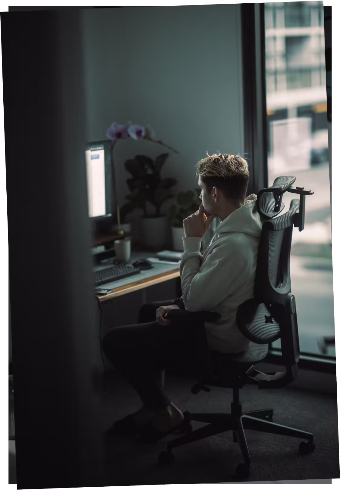 a man sitting in a chair looking at a computer screen
