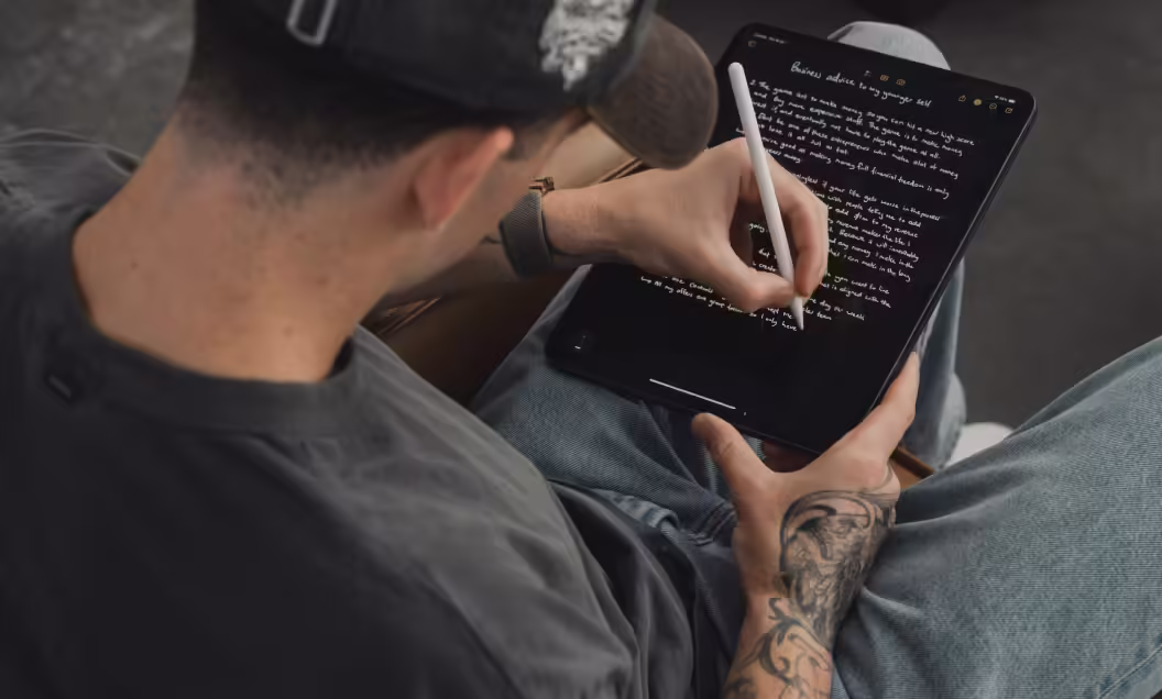 a man writing on a tablet