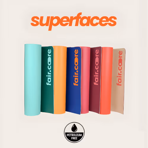 Cinq petites bouteilles de jus colorés de la marque Paf, avec un morceau de gingembre et un demi-citron à côté d'un verre de jus vert.