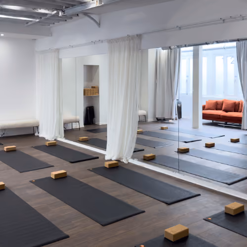 Tapis noirs et blocs de yoga installés face aux miroirs du studio Yoze Arts et Métiers 2.