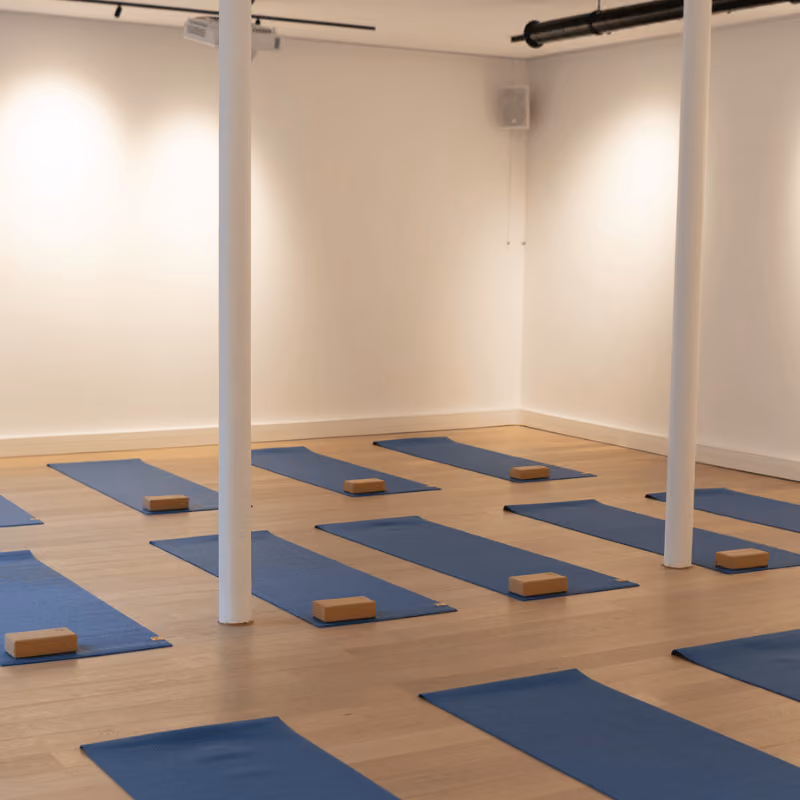 Tapis de yoga et briques disposés sur le parquet de la salle Charonne – Atelier 77