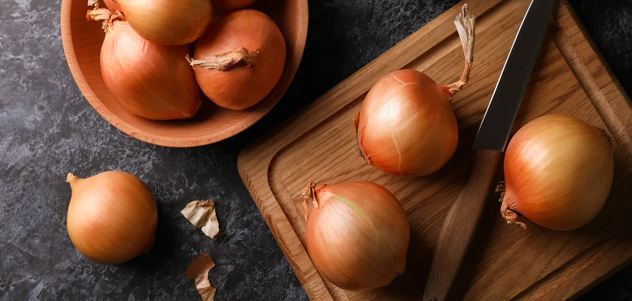 Fresh white onions on wooden board, premium wholesale supply from Ukraine for UK and EU buyers