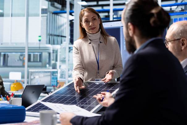 Beratungsgespräch zu Solaranlage, Hand zeigt auf Solarstrom-Panel