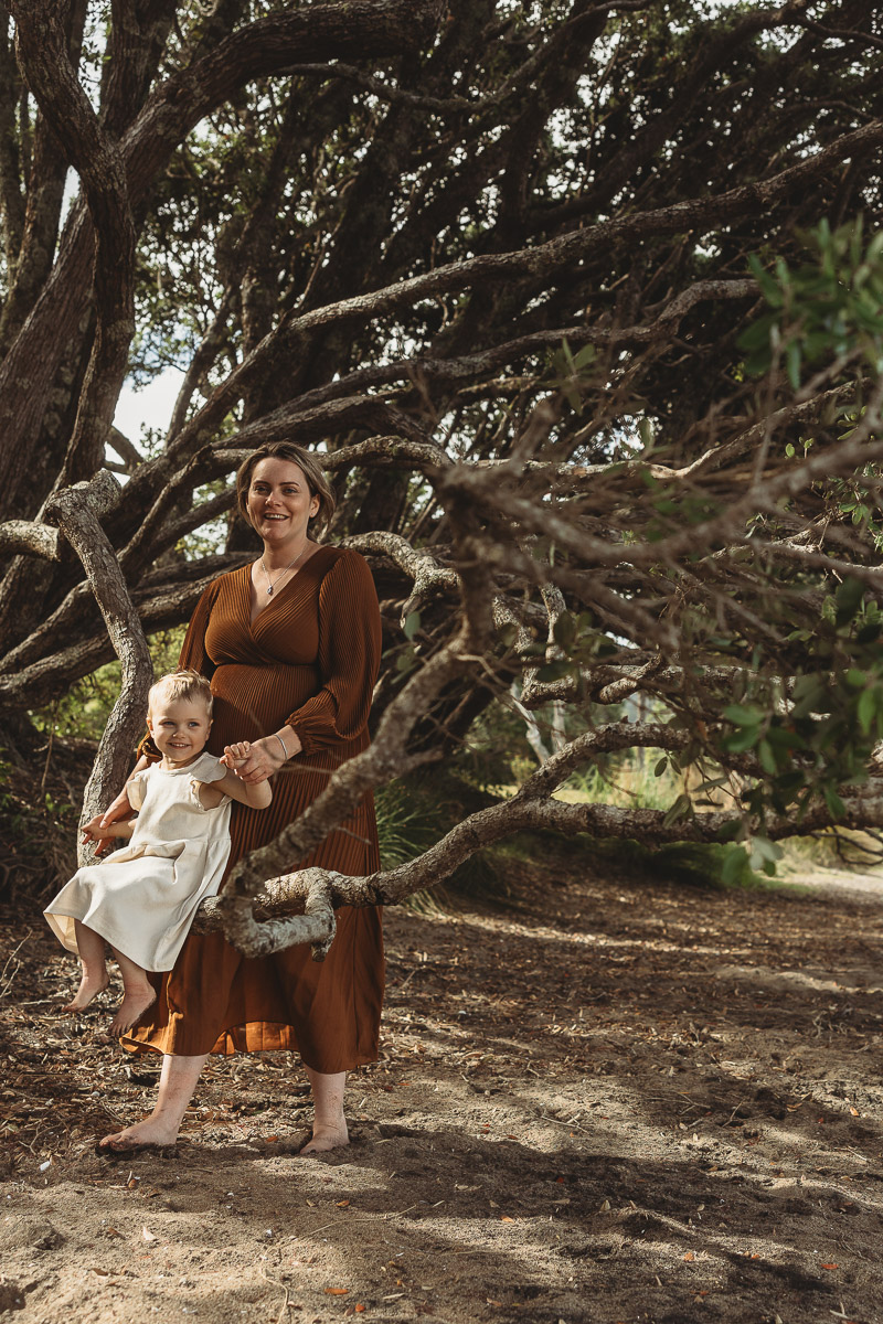 Mother balances daughter on a branch