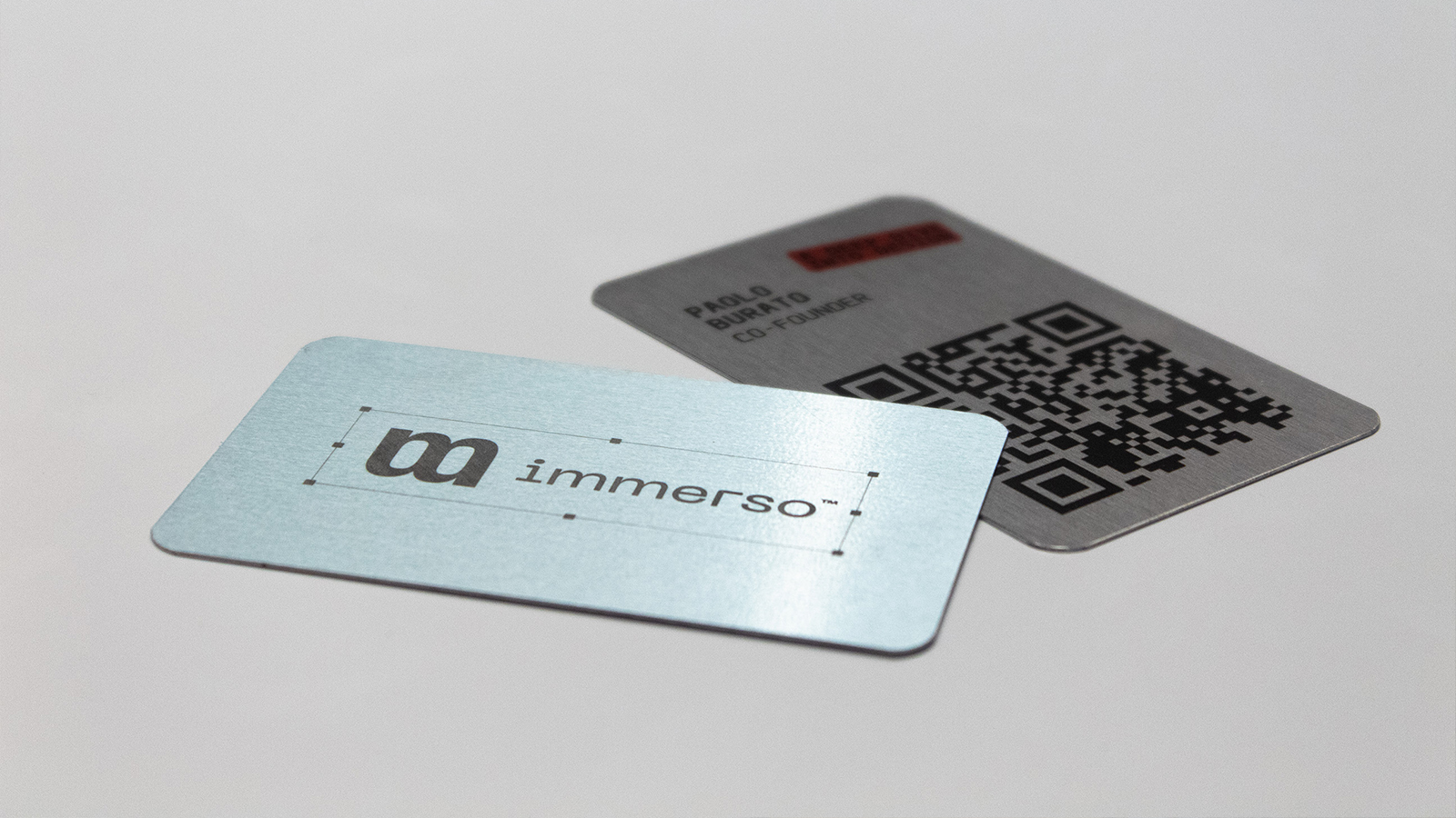 Carte Immerso con logo grigio e codice QR su sfondo chiaro