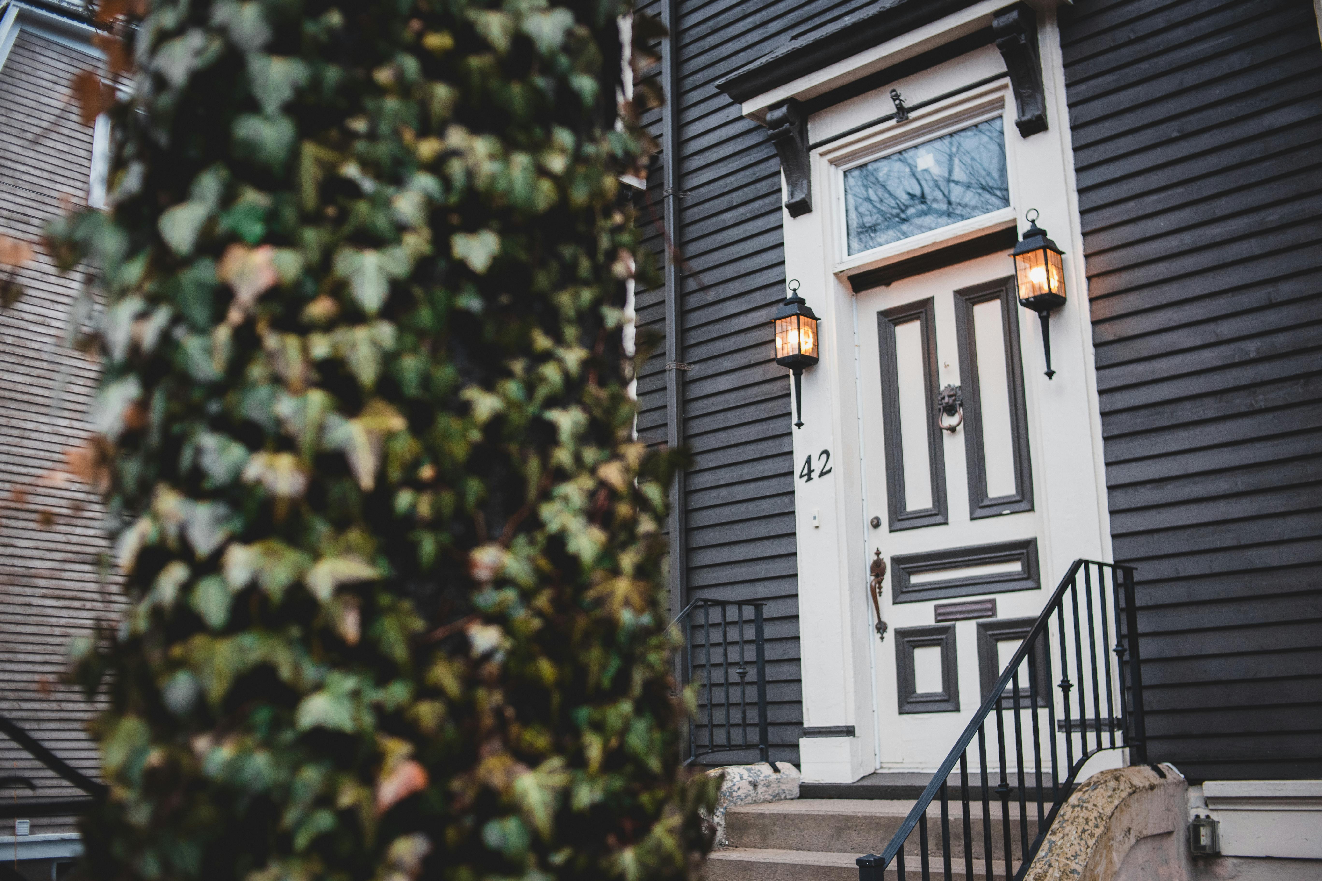 A black house featuring a white front door and steps, symbolizing a residential property.
