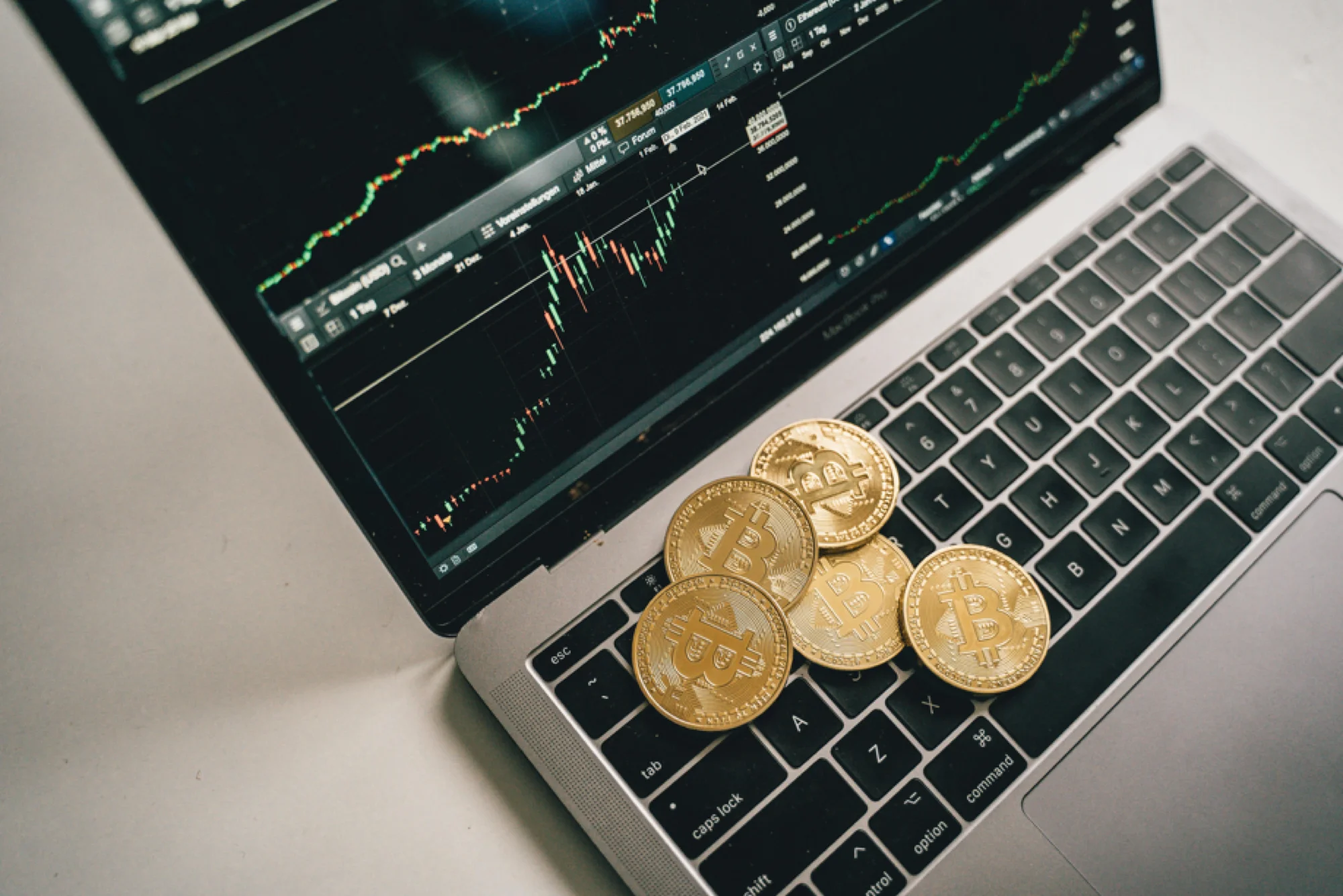 Bitcoin and gold coins on a laptop, symbolizing the importance of securing digital assets in estate planning.