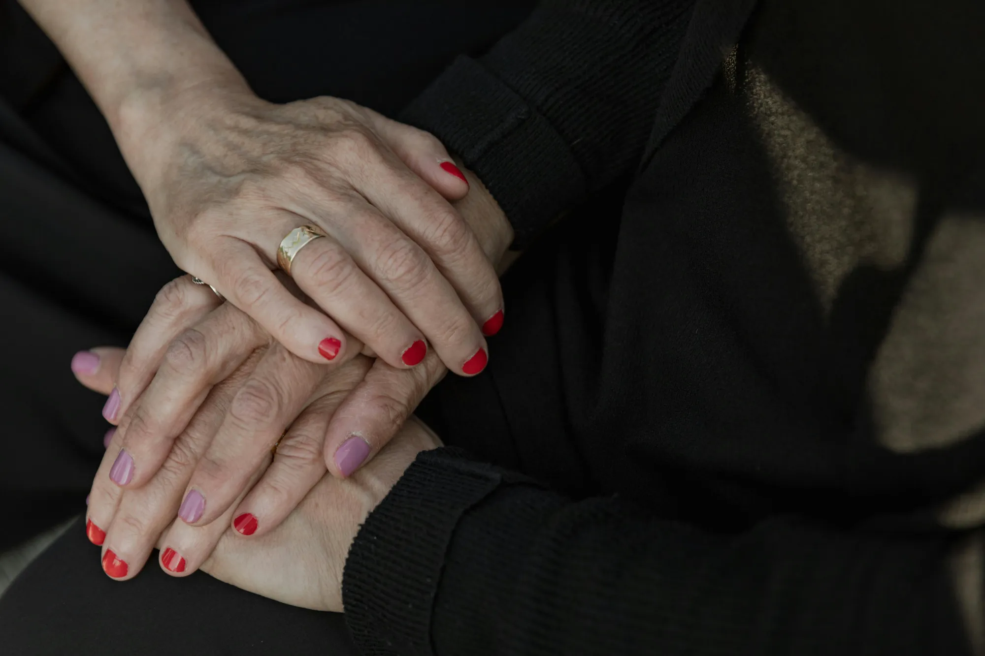 Two elderly women holding hands, symbolizing support and connection during discussions about 401(k) inheritance and beneficiaries.