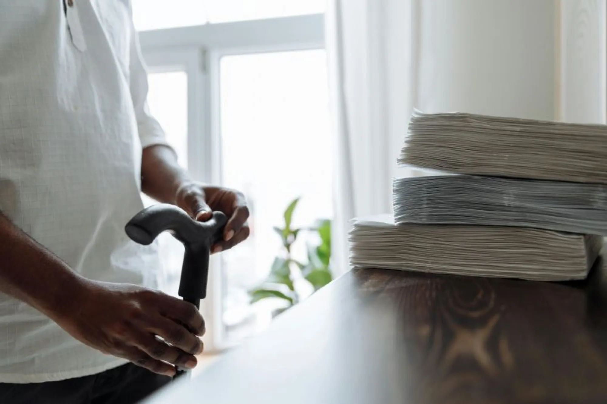 A man with a cane holds a stack of papers, symbolizing organization and support for estate planning.