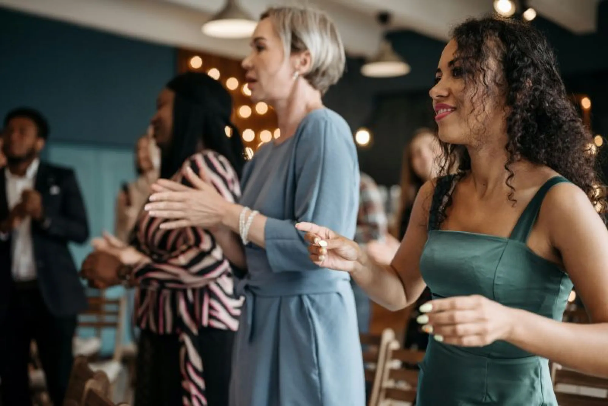A group of people joyfully clapping during a wedding celebration, expressing happiness and support for the couple.