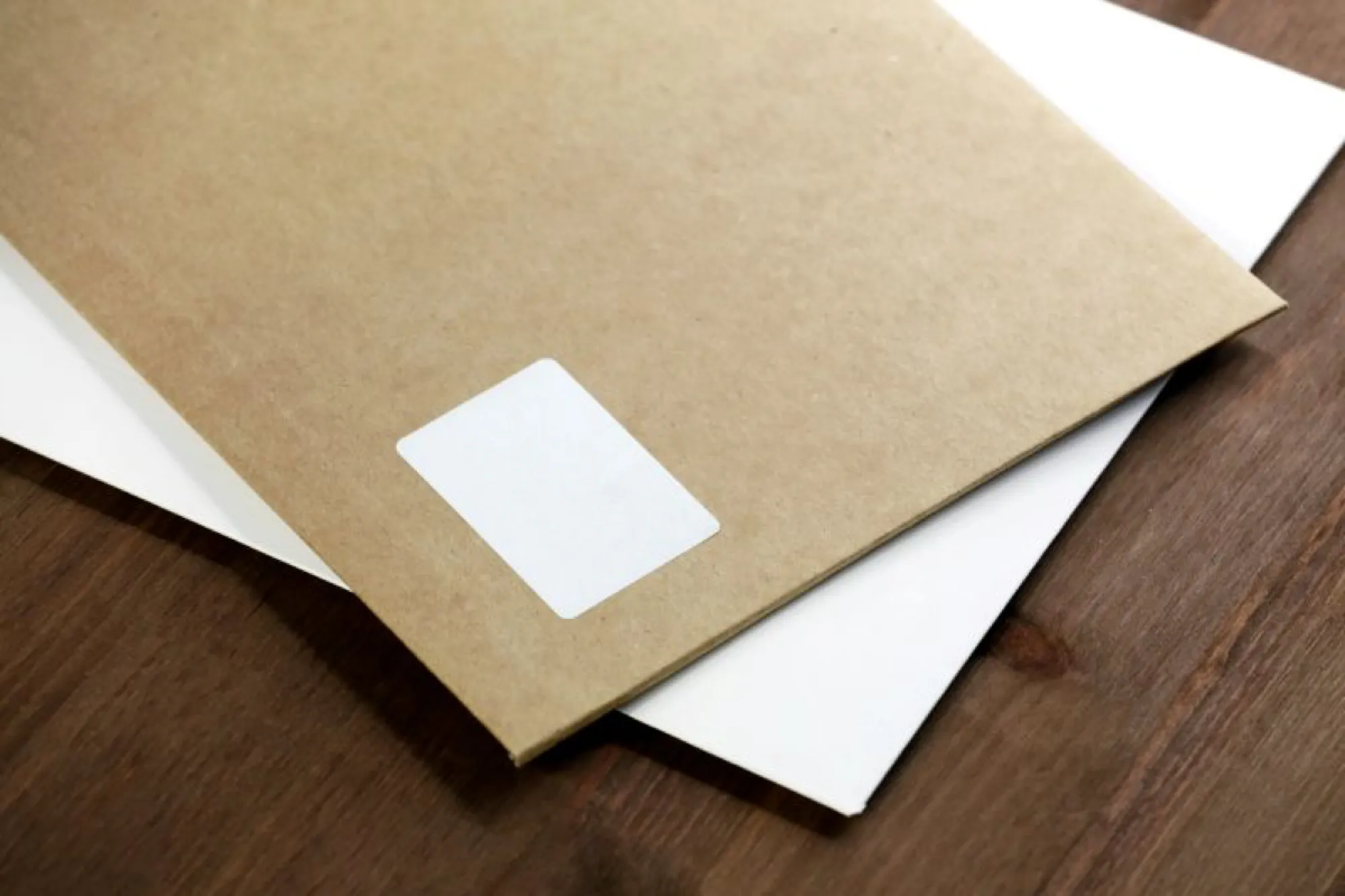 A brown envelope with a white sticker on top, possibly containing important documents like a death certificate request.
