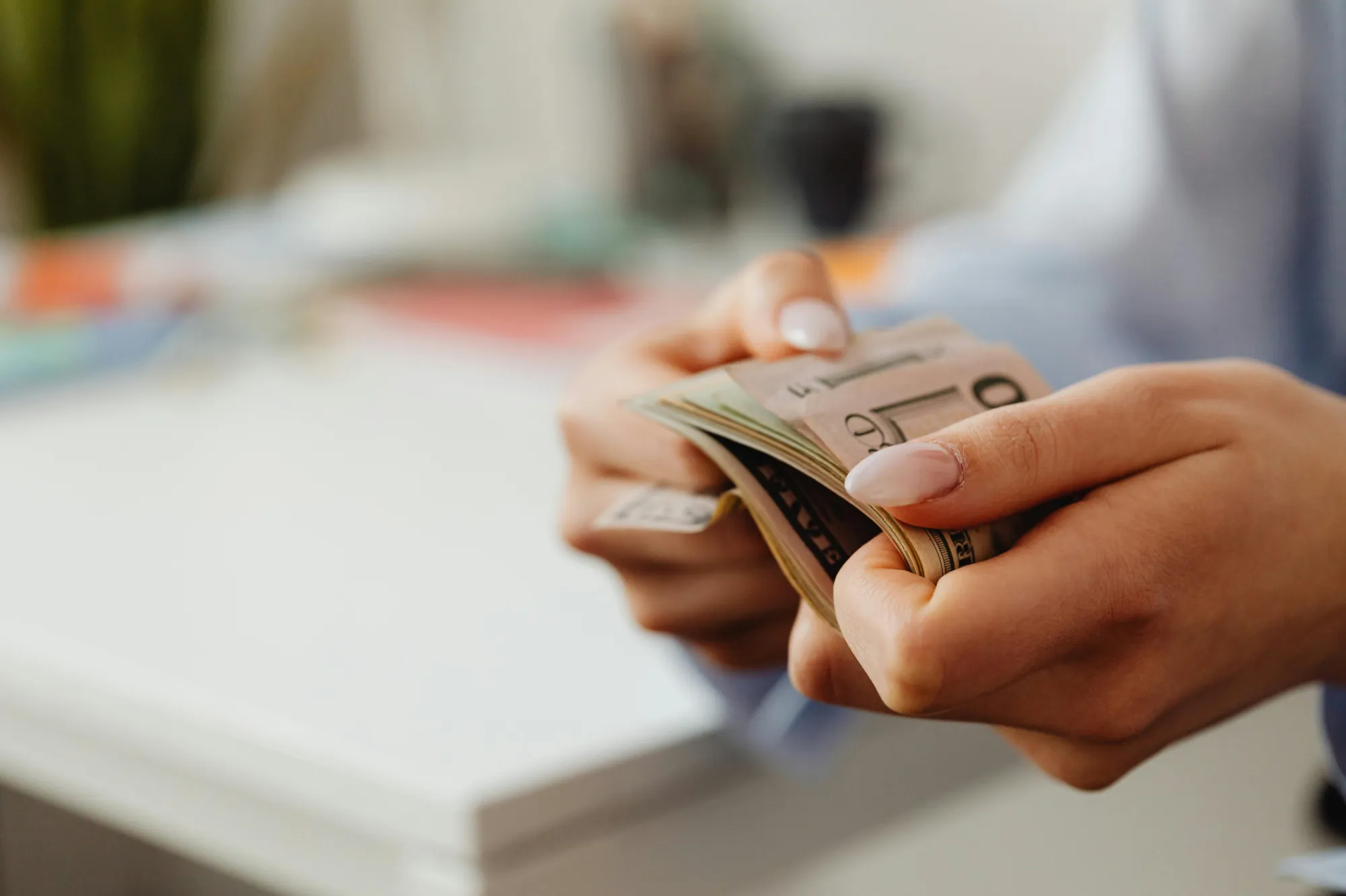 A person holding cash in their hands, symbolizing financial matters related to bank accounts and beneficiaries.