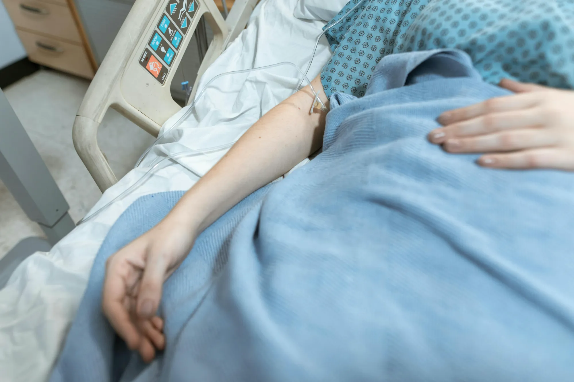 A person resting in a hospital bed, illustrating the hospice care experience for families.