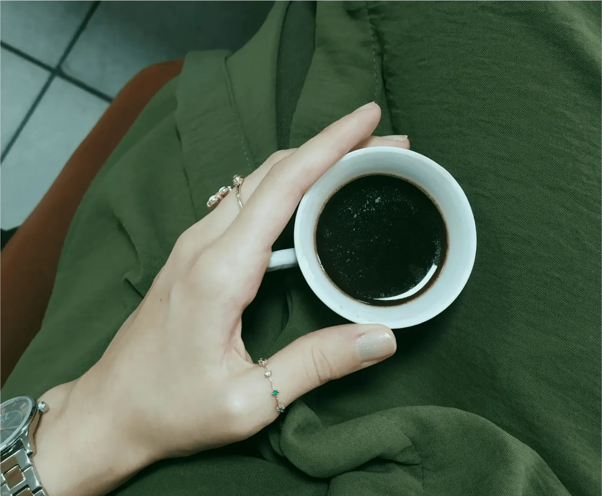A person holding a cup of coffee, symbolizing the importance of closing accounts after a loved one's passing.