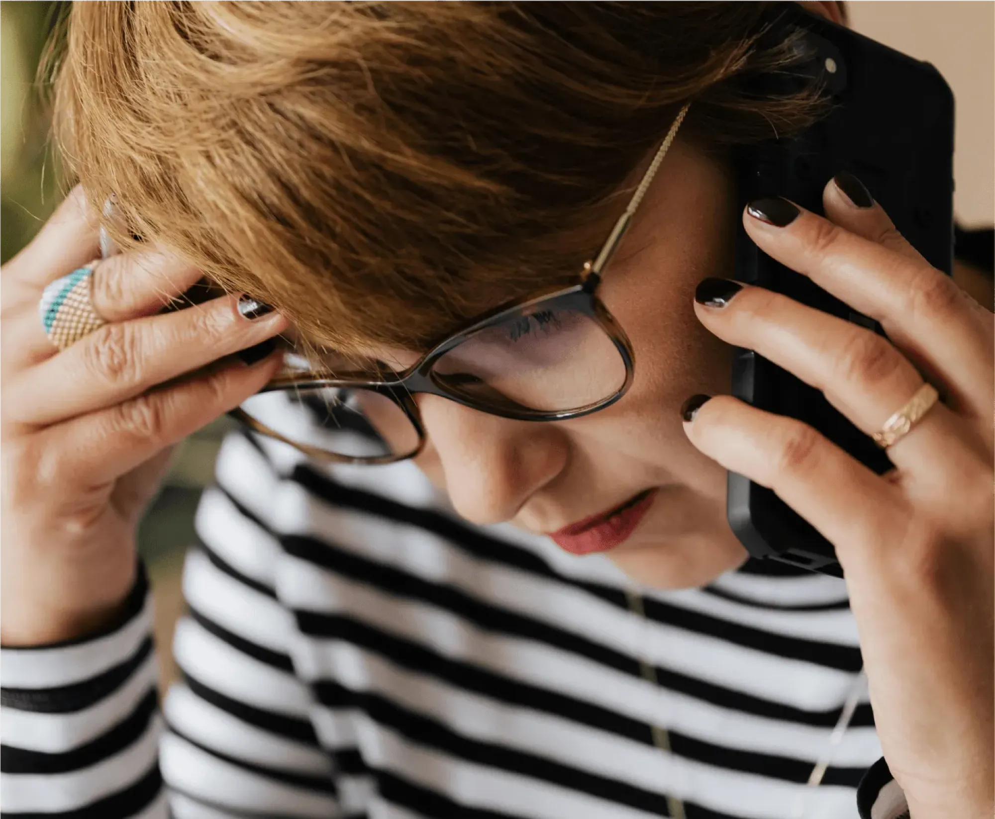 A woman in glasses and a striped shirt holds her head, reflecting the emotional weight of announcing a death.