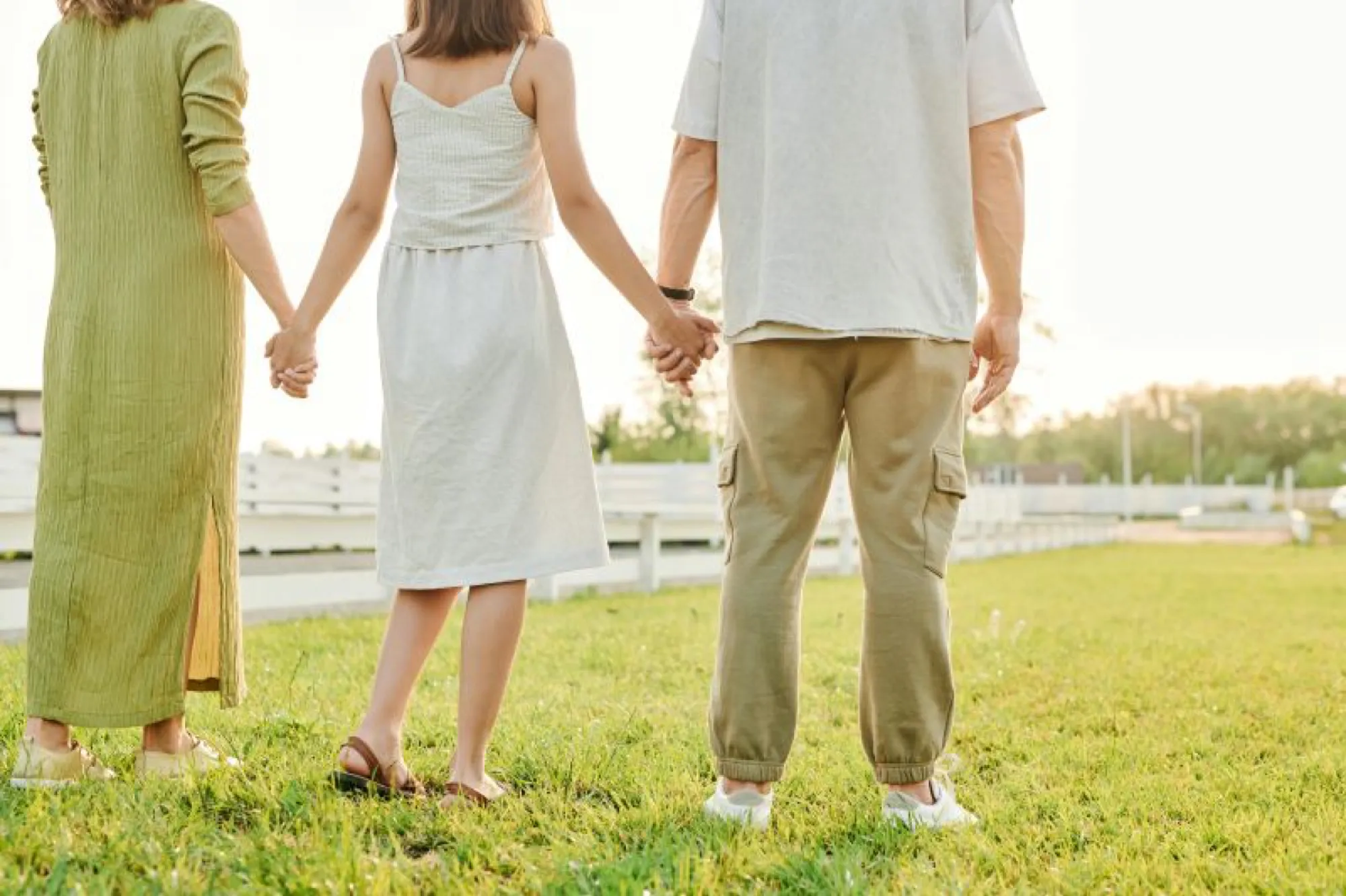 Couple holding hands, walking together in a park, enjoying a peaceful moment amidst nature.